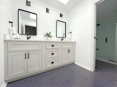 a bathroom with two sinks, mirrors and a shower stall in the middle of it