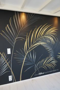 the wall is painted with gold and silver leaves on it, along with a black background