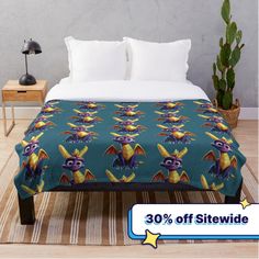 an image of a bed with a blanket on it that has a bat pattern and is next to a potted plant