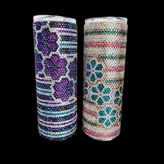 two vases made out of beads and stones on a black background, one is decorated with flowers