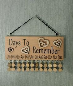 a wooden sign hanging from the side of a wall with hearts and words on it