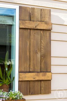 a window with wooden shutters and potted plants