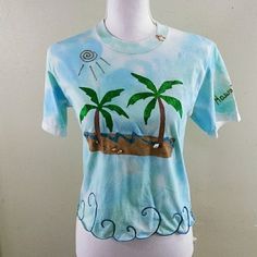 Hand Painted One-Of-A-Kind Tropical T-Shirt S When I Lived In Hawaii I Sold My One-Of-A-Kind T-Shirts At A Gift Shop In The King Kamehameha Hotel, And Recently Came Across A Few I Had Left. This One Measures Approx. 17" From Armpit To Armpit And Is About 19" In Length. I'd Recommend Hand Washing Because It's Decorated With Real Seashells. Note: Hand Painted; Imperfections Are A Part Of The Uniqueness Of The Top. Price Firm! A Lot Of Work Went Into This, And It's Already Discounted. Blue Cotton T-shirt For Beach Season, Blue Short Sleeve T-shirt For Beach Season, Light Blue Short Sleeve Tops For Beach Season, Light Blue Crew Neck Shirt For Summer, Light Blue Graphic Tee For Summer, Light Blue Cotton T-shirt For Beach, Blue Crew Neck Tops For Beach Season, Blue Crew Neck Summer Top, Light Blue Cotton T-shirt For The Beach