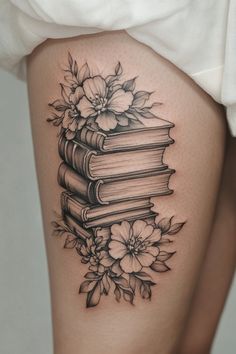 a woman's thigh with books and flowers on it