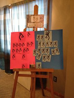 an easel with several pieces of art on it in front of a curtained window