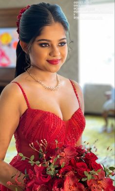 a woman in a red dress holding a bouquet