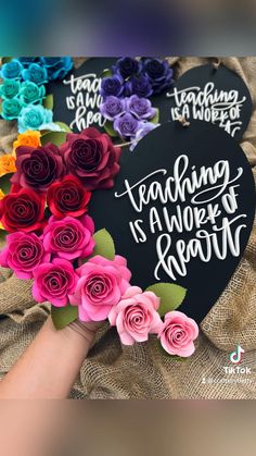 there is a heart shaped sign with flowers on it and the words teaching is awesome