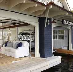 a living room and dining area are on the water in front of a boat dock