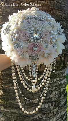 a bridal bouquet is attached to a tree with pearls and other jewelry on it