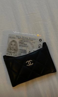 a black wallet sitting on top of a bed next to a white sheet with a card sticking out of it