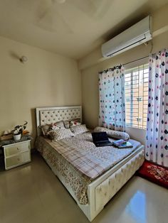 a bed room with a neatly made bed and curtains