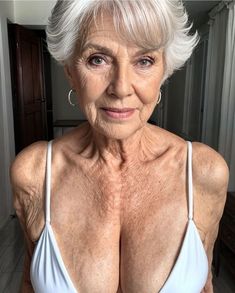 an older woman with white hair wearing a bra