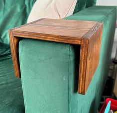 a wooden table sitting on top of a green couch