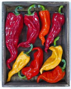 red, yellow and green peppers in a wooden box