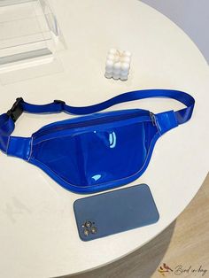 a blue fanny bag sitting on top of a table next to a cell phone and ear buds