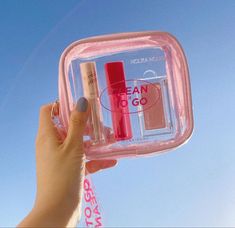 a person holding up a clear container with two different items in it and the sky behind them