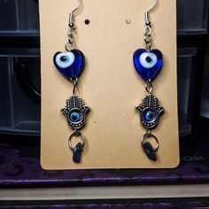 Beautiful Evil Eye Earrings! An evil eye is a talisman or amulet, designed in the shape of an eye, traditionally in the colours blue or green, that indicate spiritual protection. All jewelry comes with crystal crumbs! Metal Dangle Earrings With Evil Eye, Spiritual Evil Eye Dangle Jewelry, Bohemian Evil Eye Metal Jewelry, Spiritual Metal Plug Earrings As Gift, Evil Eye Symbolic Metal Jewelry, Blue Handmade Spiritual Earrings, Handmade Blue Spiritual Earrings, Symbolic Evil Eye Metal Jewelry, Blue Evil Eye Dangle Jewelry