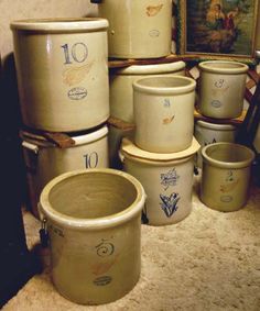 a bunch of pots sitting on the floor in front of a painting and other items