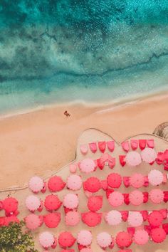 an aerial view of pink umbrellas on the beach