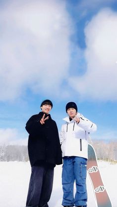 two snowboarders pose for a photo in the snow