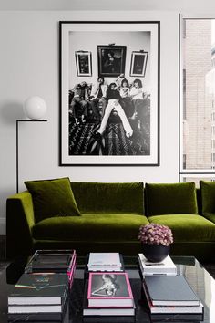 a living room with green couches and pictures on the wall