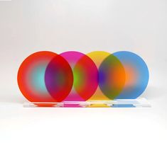 three different colored discs sitting on top of a clear stand with one disc in the middle