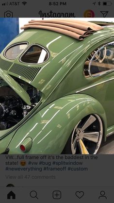 an old green vw bug parked in a garage