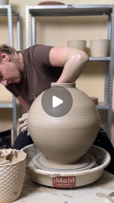 a woman is making a vase out of clay