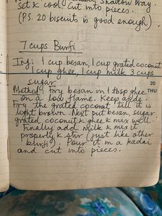 an open notebook with writing on it in front of a blue and white couch cushion