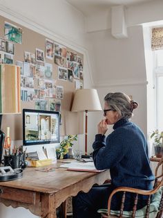 a woman sitting at a desk in front of a computer