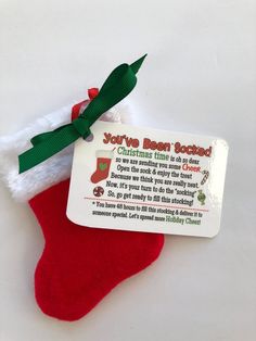 a red christmas stocking with a green ribbon and a tag attached to it that says you're born today