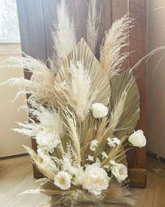 some white flowers and grass in a vase