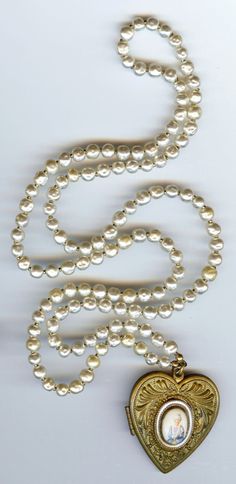 "This vintage faux Baroque pearl necklace has a heart shaped locket pendant that can be opened and closed. The front of the heart is decorated with an oval cabochon which has an image of a lady on it. Has two photos inside which can be replaced. Locket closes securely. It measures approximately 33\" in wearable length. Locket pendant is approximately 1-3/4\" by 1-5/8\" when unopened. Good condition. The lady on the font looks worn, I'm not sure if this was done intentionally. The necklace doesn' Victorian Pearl Drop Necklace For Formal Occasions, Formal Antique Pearl Drop Necklace, Vintage Pearl Necklace With Pendant, Antique Pearl Necklace With Pearl Pendant For Formal Occasions, Victorian Pearl Necklaces For Formal Occasions, Antique Formal Pearl Chain Necklace, Antique Pearl Chain Necklace For Formal Occasions, Antique Pearl Necklace For Formal Occasions, Victorian Pearl Chain Necklace For Formal Occasions