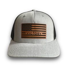 This classic trucker cap style is built with the best quality and fit while sporting the Victory Apparel American flag leather patch. Gray Trucker Snapback Hat With Curved Bill, Trucker Hat With Leather Patch And Flat Brim, Gray Trucker Baseball Cap With Flat Bill, Trucker Hat With Leather Patch And Flat Bill, Gray Trucker Snapback Hat With Flat Bill, Trucker Baseball Cap With Leather Patch, Trucker Snapback Hat With Leather Patch, Gray Snapback Trucker Hat For Baseball Season, Leather Patch Trucker Hat With Curved Bill