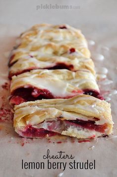 a close up of a pastry on a piece of paper with icing and strawberries