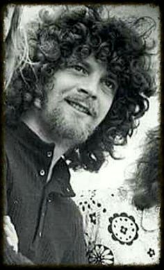 three people standing next to each other with long curly hair and beards smiling at the camera