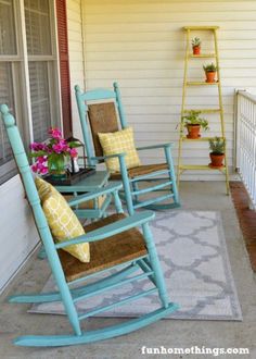 two rocking chairs on the front porch with yellow and blue pillows, potted plants