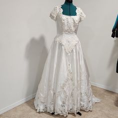 a white wedding dress on display in a room