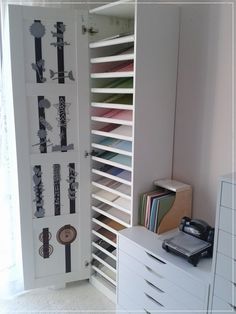 a room with many different colored papers on the wall and drawers in front of it