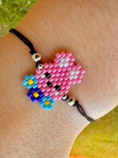 a person wearing a pink and blue beaded bracelet on their arm with beads attached to it