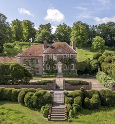 an aerial view of a large house surrounded by hedges