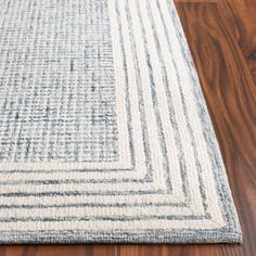 a blue and white area rug on a wooden floor with wood floors in the background