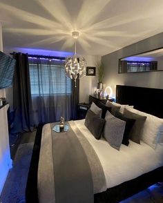 a bedroom with a bed, mirror and lights on the wall above it's headboard