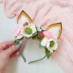 a person is holding a flower crown made out of fake flowers and felt materials