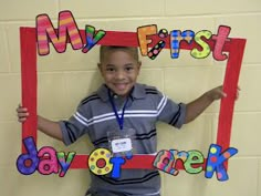 a young boy holding up a sign that says my first day of school