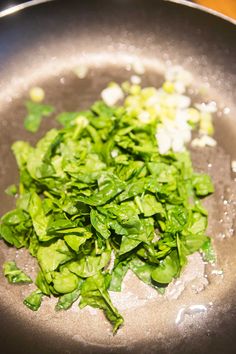 green vegetables are being cooked in a wok