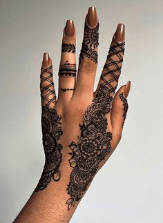 a woman's hand with henna tattoos on it