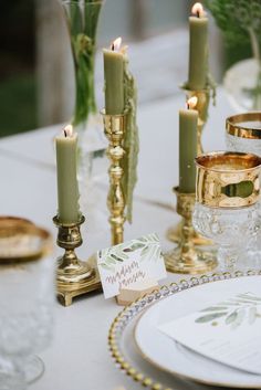 the table is set with candles and place cards