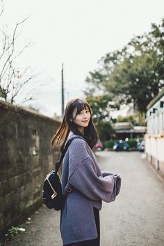 a woman standing on the side of a road