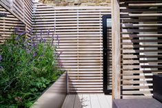 an outdoor area with wooden slats and plants